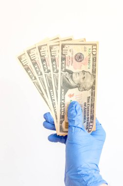 Ellerinde cerrahi eldivenlerle 10 Amerikan doları banknotları. Alexander Hamilton 'ın portresi olan bir banknot. Covid-19 Coronavirus salgını. Durma ve Covid-19 konseptini koruma kavramı.