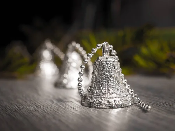 Closeup Photograph Silver Christmas Bells Beaded Strand Gray Woodgrained Floor — Stock Photo, Image