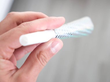 Bir hologram baskı gümüş renkli karton ve plastik yılbaşı kutlama boynuz elinde tutan bir kafkas erkek portre fotoğrafı.