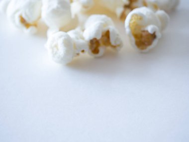 Lezzetli görünümlü arka plan veya duvar kağıdı görüntü için aşağıdaki beyaz boşluk ile görüntünün üst kısmında izole beyaz tuzlanmış patlamış mısır çekirdeği parçaları makro fotoğraf kadar yakın.