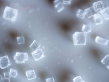 An extreme closeup macro microscopic image of a pile of clear cubed salt crystals showing the intricate detailing of the common cooking ingredient, preservative, and flavoring. clipart