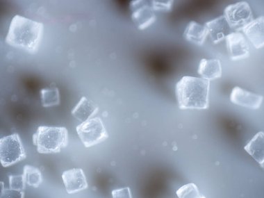 An extreme closeup macro microscopic image of a pile of clear cubed salt crystals showing the intricate detailing of the common cooking ingredient, preservative, and flavoring. clipart