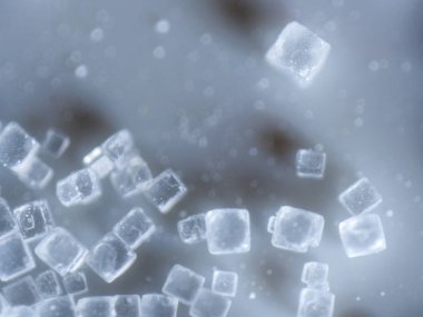 An extreme closeup macro microscopic image of a pile of clear cubed salt crystals showing the intricate detailing of the common cooking ingredient, preservative, and flavoring. clipart