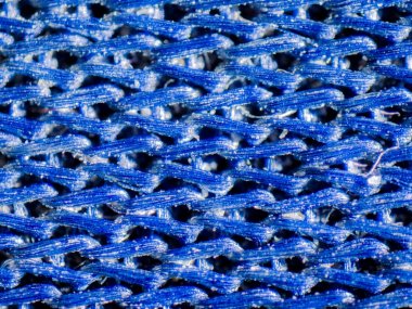 İş parçacıkları arasında kapsüllenmiş toz ile mavi dokuma bir aşırı closeup makro ayrıntı mikroskobik görüntü.