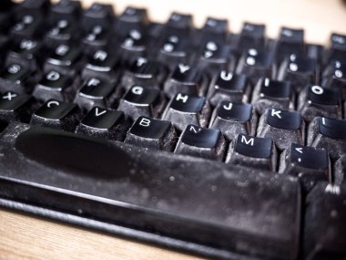 Görüntü brüt kirli ve tozlu yıpranmış siyah bilgisayar klavye ile mektup ve Ara Çubuğu'na bir ahşap tahıl masanın üzerinde görünür kapatın.