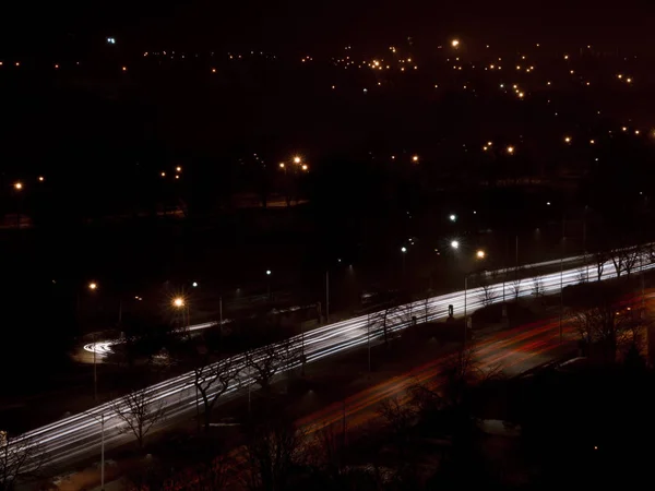 Photograph of red and white traffic light trails from head lamps and tail lights along Lake Shore Drive highway in Chicago on a cold winter night using long exposure photography.