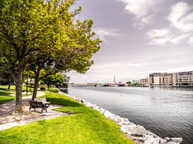 Güzel manzara sahne sadece Green Bay Wiscosin sunrise riverwalk ile iz sonra Fox nehir boyunca vurdu, tezgah, ağaç, ot ve kayalık kıyı atış ve mavi çerçeveleme dolu gökyüzü bulut.
