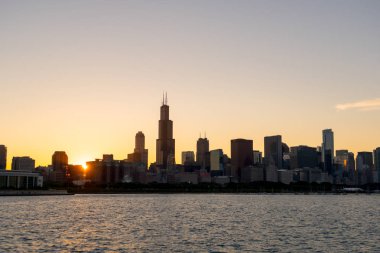 Chicago manzarası resim siluetleri bina ve dalgalar Michigan Gölü su ön planda dalgalanan güzel gün batımı sırasında
