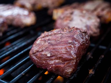 Yakın çekim fotoğraf Dana fileto mignon ve t-bone biftek bir arka bahçe Barbekü için bir gaz ateş ızgarada dahil olmak üzere çeşitli kesim.