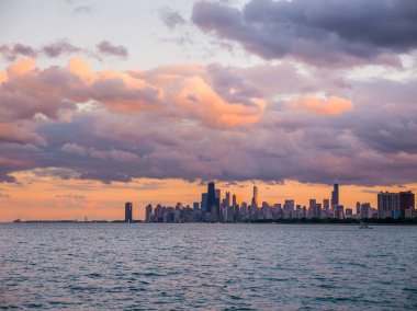 Ufuk ve ön planda Michigan Gölü ve pembe, turuncu ve mor kabarık bulutlar gökyüzünde yukarıdaki binaları ile güzel Chicago siluetinin muhteşem manzara panoramik fotoğraf.