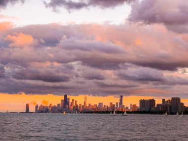 Ufuk ve ön planda Michigan Gölü ve pembe, turuncu ve mor kabarık bulutlar gökyüzünde yukarıdaki binaları ile güzel Chicago siluetinin muhteşem manzara panoramik fotoğraf.