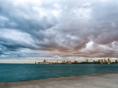 Ufuk ve ön planda Michigan Gölü ve pembe, turuncu ve mor kabarık bulutlar gökyüzünde yukarıdaki binaları ile güzel Chicago siluetinin muhteşem manzara panoramik fotoğraf.