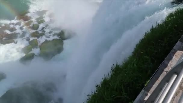 Vista panorámica de cerca de la cascada de American Falls en Niágara Nueva York, comenzando con vista al borde del acantilado con el agua explotando en las rocas de abajo y terminando con vista al agua hacia Canadá — Vídeos de Stock