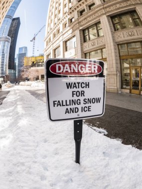 Chicago, Il - 12 Şubat 2018: ısınma hava buz ve kar çatılar ve yüksek binaların duvarları üzerinden gevşetir gibi işaretler Chicago şehir merkezinde kaldırımlar çöp uyarı düşen buz.
