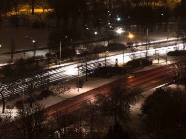 Uzun pozlama fotoğraf araba far ve kuyruk hafif çizgiler ya da üstünde Lake Shore Chicago sokmak yollar üzerinde koruyucu beach Altgeçit hız sınırı işareti ve karda çıplak ağaçları ile kaplı zemin.
