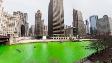 Chicago, IL - 17 Mart 2018: Tekneler manevra Chicago Nehri şehrin yıllık St Patrick's Day kutlamaları sırasında üzerinde parlak yeşil su ile.