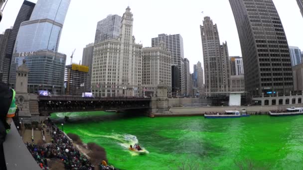 Chicago, Il - 17 maart-2018: Drukte vorm langs de Chicago River op zaterdag om naar te kijken de rivier groen tijdens het jaarlijkse St. Patrick's Day viering van de stad. — Stockvideo