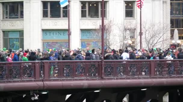 Chicago, il - 17. März 2018: Menschenmassen drängen sich am Samstag über die Brücke an der Michigan Avenue, um zu sehen, wie sich der Chicago River während des jährlichen St. Patrick 's Day der Stadt grün färbt.. — Stockvideo