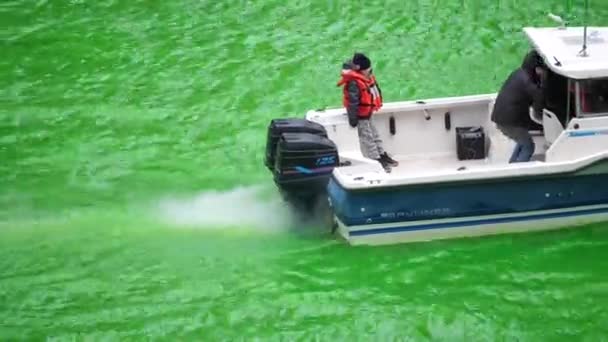 Chicago, IL - 17 mars 2018 : Un enfant roule à l'arrière d'un bateau alors qu'il descend la rivière Chicago fraîchement teinte en vert samedi lors de la célébration annuelle de la Saint-Patrick . — Video