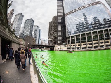 Chicago, IL - 17 Mart 2018: İnsanlar yürüyüş taze yeşil boyalı Chicago Nehri boyunca kayık tekneler geçişi tarafından Cumartesi günü kentin yıllık St Patrick's Day kutlamaları sırasında olarak Cumartesi günü.