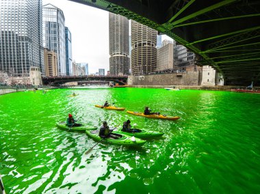 Chicago, IL - 17 Mart 2018: Kayak yapmak yollarını downtown Chicago şehir yıllık St Patrick's Day kutlamaları sırasında taze boyalı yeşil nehirde.