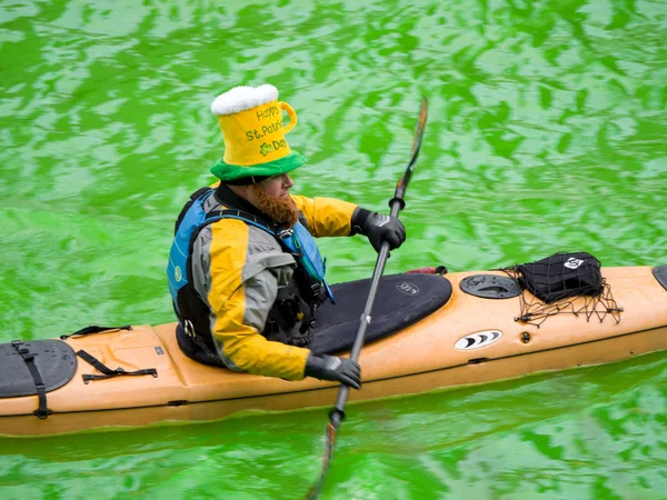 Chicago, IL - 17 Mart 2018: Kayak yapmak yollarını downtown Chicago şehir yıllık St Patrick's Day kutlamaları sırasında taze boyalı yeşil nehirde.