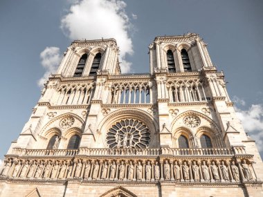 Güzel turistik seyahat fotoğraf dünya ünlü ve tarihi Gotik Notre Dame Katolik Katedrali Paris ön cephe bakarak yukarıdaki mavi gökyüzünde Fransa beyaz bulutlar.