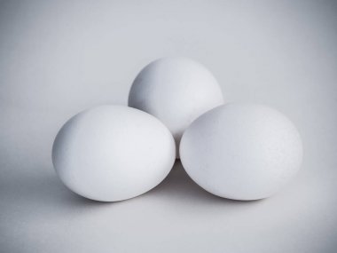 Üç gerçek beyaz tavuk yumurtası doğal ışık ve gölge beyaz bir arka plan üzerinde bir grup güzel fotoğraf.