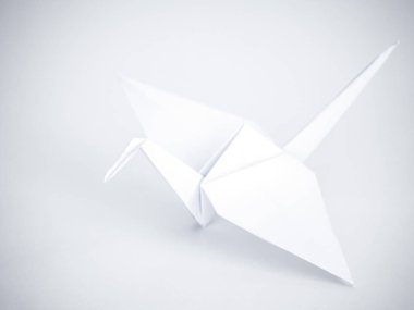 Güzel geleneksel Japon origami turna veya orizuru beyaz bir arka plan üzerinde beyaz katlanmış kağıt yapılmış.