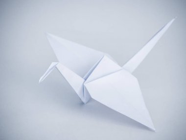 Güzel geleneksel Japon origami turna veya orizuru beyaz bir arka plan üzerinde beyaz katlanmış kağıt yapılmış.