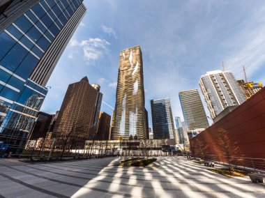 Chicago, Il - 21 Mart 2018: İnşaat ekipleri çalışmalarına firma sahibi kadın yakın rekor kırarak Vista kule highrise bina olarak Jeanne çetenin 82 hikaye Aqua Tower sıcak güneşin yansıtır.