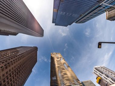 Chicago, Il - 21 Mart 2018: İnşaat ekipleri çalışmalarına firma sahibi kadın yakın rekor kırarak Vista kule highrise bina olarak Jeanne çetenin 82 hikaye Aqua Tower sıcak güneşin yansıtır.