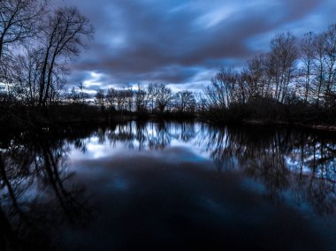 Fantastik güzel uzun pozlama günbatımı fotoğrafı ile ağaçlar ve gökyüzü bir gölet Wisconsin muhteşem bir arka plan yapma sakin suda yansıtılmış yansıması ile mavi ve pembe bulutların üzerinde.
