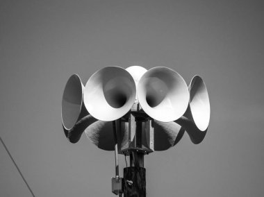 Close up photograph of several multi directional round amplified emergency siren  or noon time horns on top of a wooden pole in a small town in Wisconsin. clipart