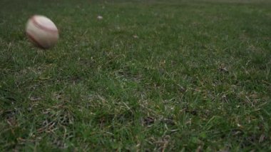 Havada attı ve çim kaplı zeminde bir düşük iyi spor arka plan yapma noktadan açılış kırmızı dantel ile kullanılan deri beyzbol kısa yavaş hareket % 50 yarı hızla video klip