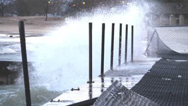 Büyük dalgalar gürültüyle çarpmak ve katmanlı beton bariyerler ve splash Foster Beach yakınındaki yakındaki yürüyen yüzeyinde içine Chicago Edgewater mahallede soğuk rüzgarlı bir günde patlayabilir..