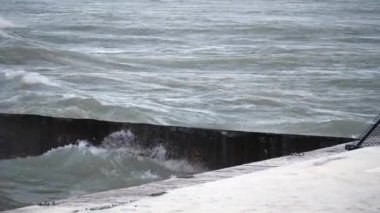Yavaş hareket in büyük dalgalar gürültüyle çarpmak ve katmanlı beton bariyerler ve splash Foster Beach yakınındaki yakındaki yürüyen yüzeyinde içine Chicago Edgewater mahallede soğuk rüzgarlı bir günde patlayabilir..