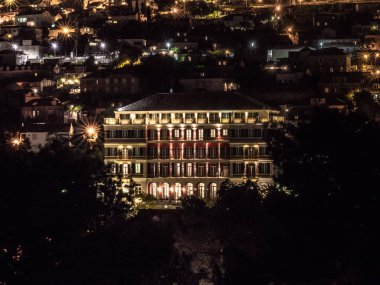 Dubrovnik, Hırvatistan - 28 Nisan 2018: Renkli ışıklar şehir ve Adriyatik Denizi manzaralı diğer konutlar arasında tepe üzerinde oturur gibi tarihi Hilton Imperial Hotel geceleri yanar.