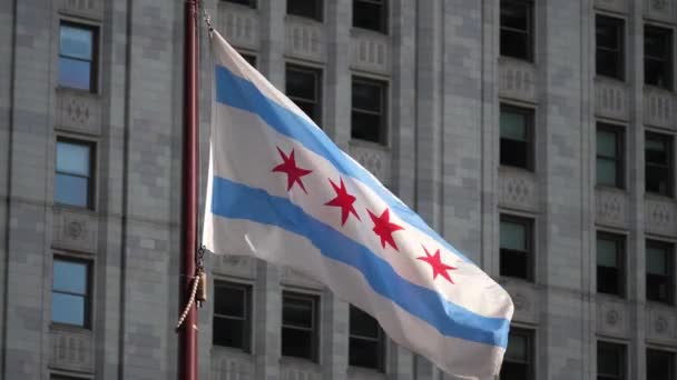 靠近一个慢镜头 一个芝加哥国旗飘扬着 在风中飘扬 背后是市中心的一幢高楼 — 图库视频影像