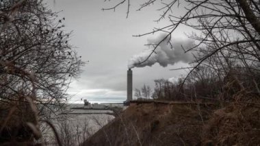 Oak Creek, Wi - 28 Kasım 2019: Oak Creek kömür santralindeki bir duman yığını eriyen Lakefront kayalıklarının yakınlarındaki bulutlu gökyüzüne duman püskürtür..