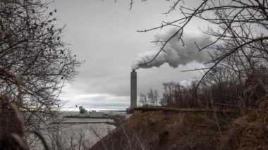 Oak Creek, Wi - 28 Kasım 2019: Oak Creek kömür santralindeki bir duman yığını eriyen Lakefront kayalıklarının yakınlarındaki bulutlu gökyüzüne duman püskürtür..