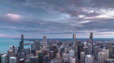 Gün be gece, Chicago şehir merkezinde inanılmaz bir gün batımı gökyüzü bulutlar parlarken gökdelenlerin üzerinde parlak mavi ve turuncu renkler süzülürken ışıklar yanar..