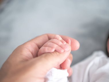 Yeni doğmuş bir çocuk babasının küçük parmaklarını babasının büyük parmağına sarıp sımsıkı tutar..