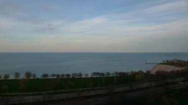 Gök Michigan Gölü 'nün üzerinde pembeden maviye dönerken, araçların Lake Shore yolunda ışık yollarına dönüşmesiyle, günden geceye geçiş zamanı..