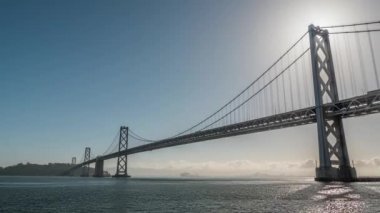 San Francisco, CA - 20 Nisan 2017: Güneş, San Francisco Oakland Körfezi Köprüsü 'nün kablosunu taşıyan kulelerden birinin çaprazında parlıyor..