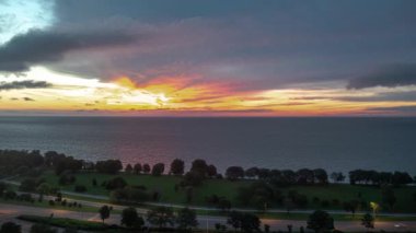 Chicago, IL - 17 Temmuz 2017: Edgewater Mahallesi 'ndeki Lake Shore Drive boyunca trafik yoğunlaşırken gökyüzü pembe, turuncu ve sarı renklerle doluyor..