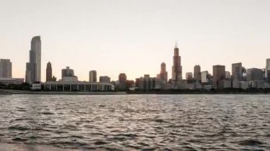 Chicago, IL - 4 Ağustos 2017: Grant Park 'ta düzenlenen yıllık müzik festivalinin dumanı yükselirken Chicago' daki gökdelenlerin arkasında parlak turuncu bir güneş batıyor..