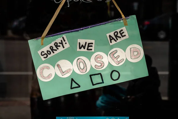 クラフト紙とリボンの文字列上の緑の手作りのサインは Covid 19流行とパンデミックの間にシカゴの店先やビジネスへのガラスの扉にかかっており 家庭の注文に滞在します — ストック写真