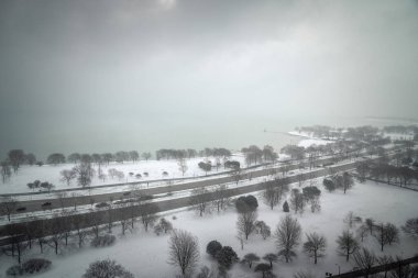 Chicago, IL - 15 Nisan 2020: Beklenmedik bir kar yağışı Edgewater civarındaki göl kenarını sabahın erken saatlerinde örtüyor.