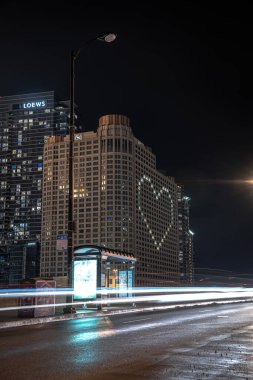 Chicago, IL - 22 Nisan 2020: COVID-19 salgını sırasında ilk müdahale ekipleri ve gerekli işçiler onuruna Sheraton Oteli 'nin ön cephesini aydınlatan ve ev siparişlerini veren bir kalp.